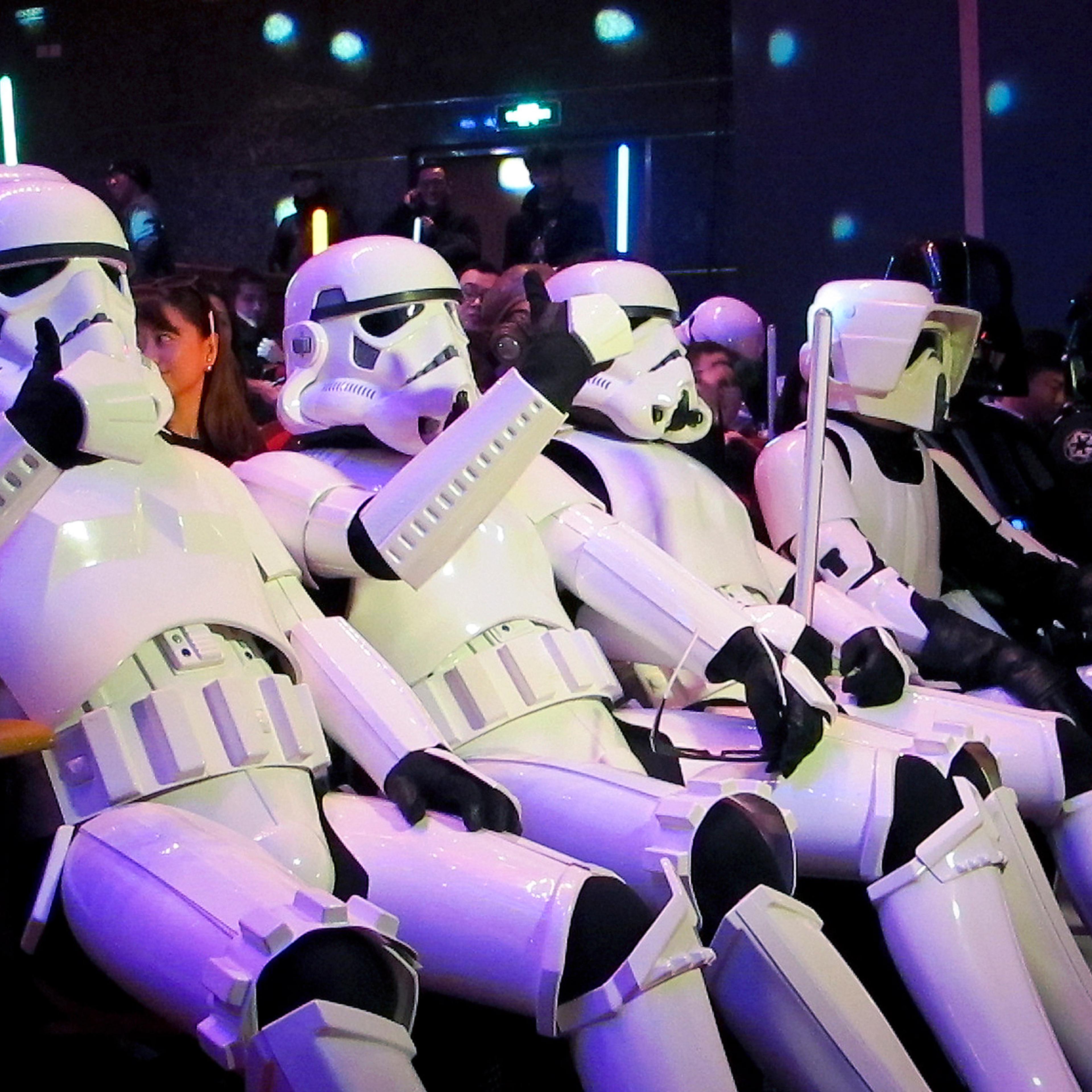 In this Sunday, Dec. 27 photo, Chinese fans, dressed as Star Wars character Stormtroopers, gesture as they arrive for the premiere of "Star Wars: The Force Awakens" in Shanghai, China. The movie has already broken the $1 billion mark, and it hasn’t even