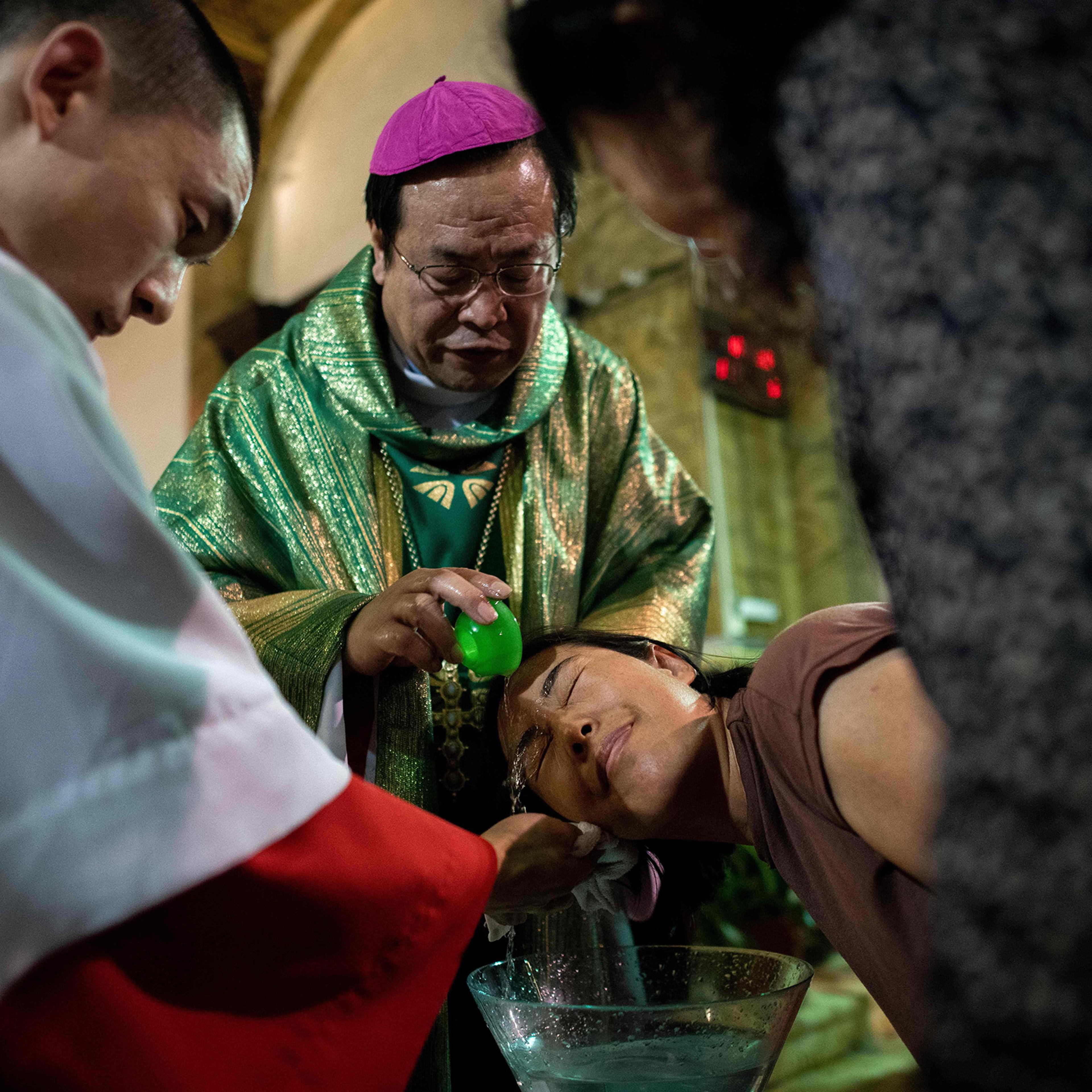 Bishop Joseph Li Shan baptizes a woman at the South Cathedral in Beijing on Sept. 22