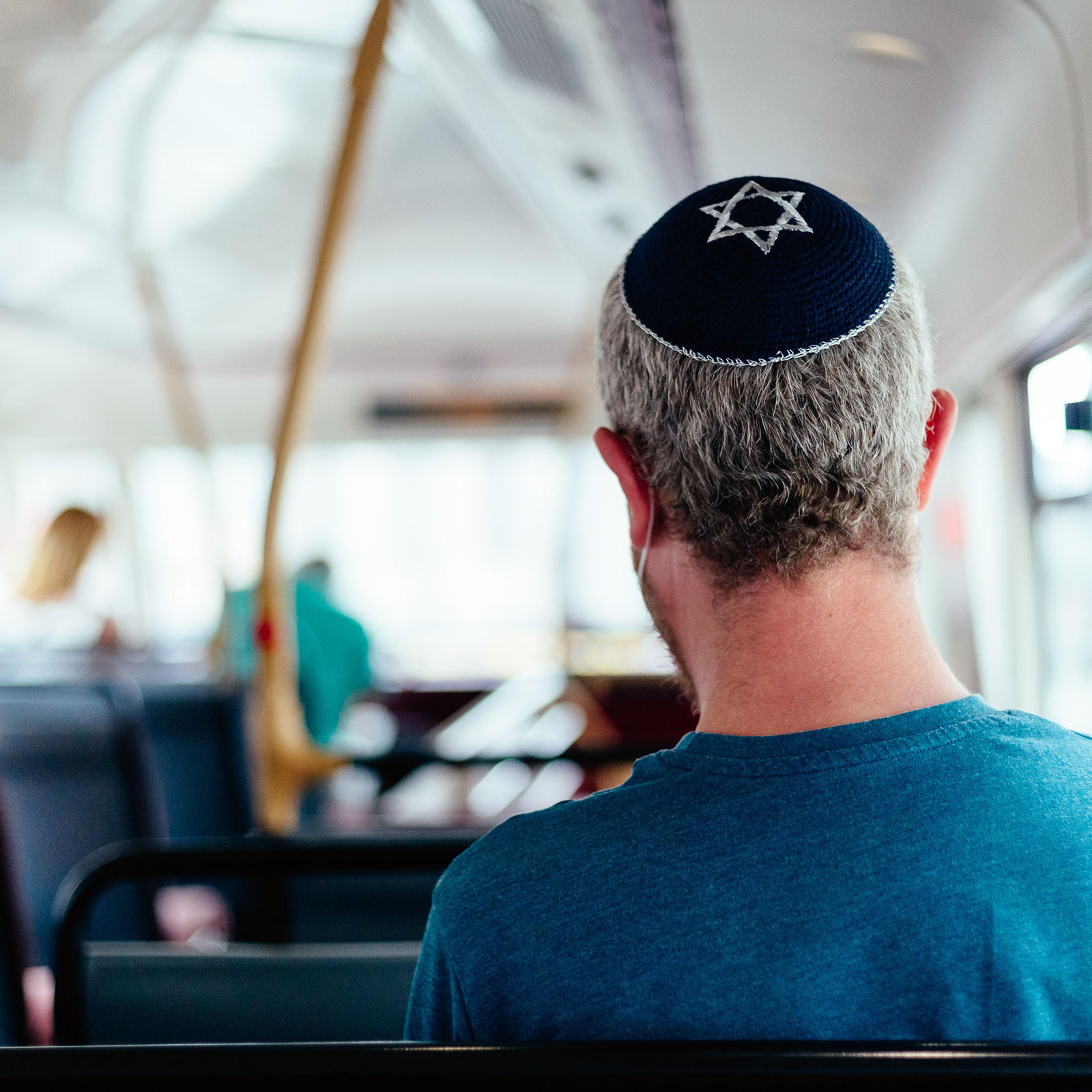 Jewish man wearing skull cap on bus in the city