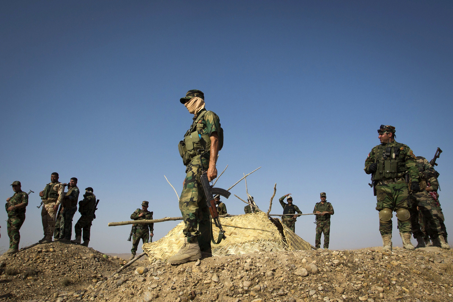 Members of Kurdish Peshmerga forces stand atop a hill during clashes with militants of the Islamic State of Iraq and Syria (ISIS) jihadist group in Jalawla in the Diyala province, on June 14, 2014.