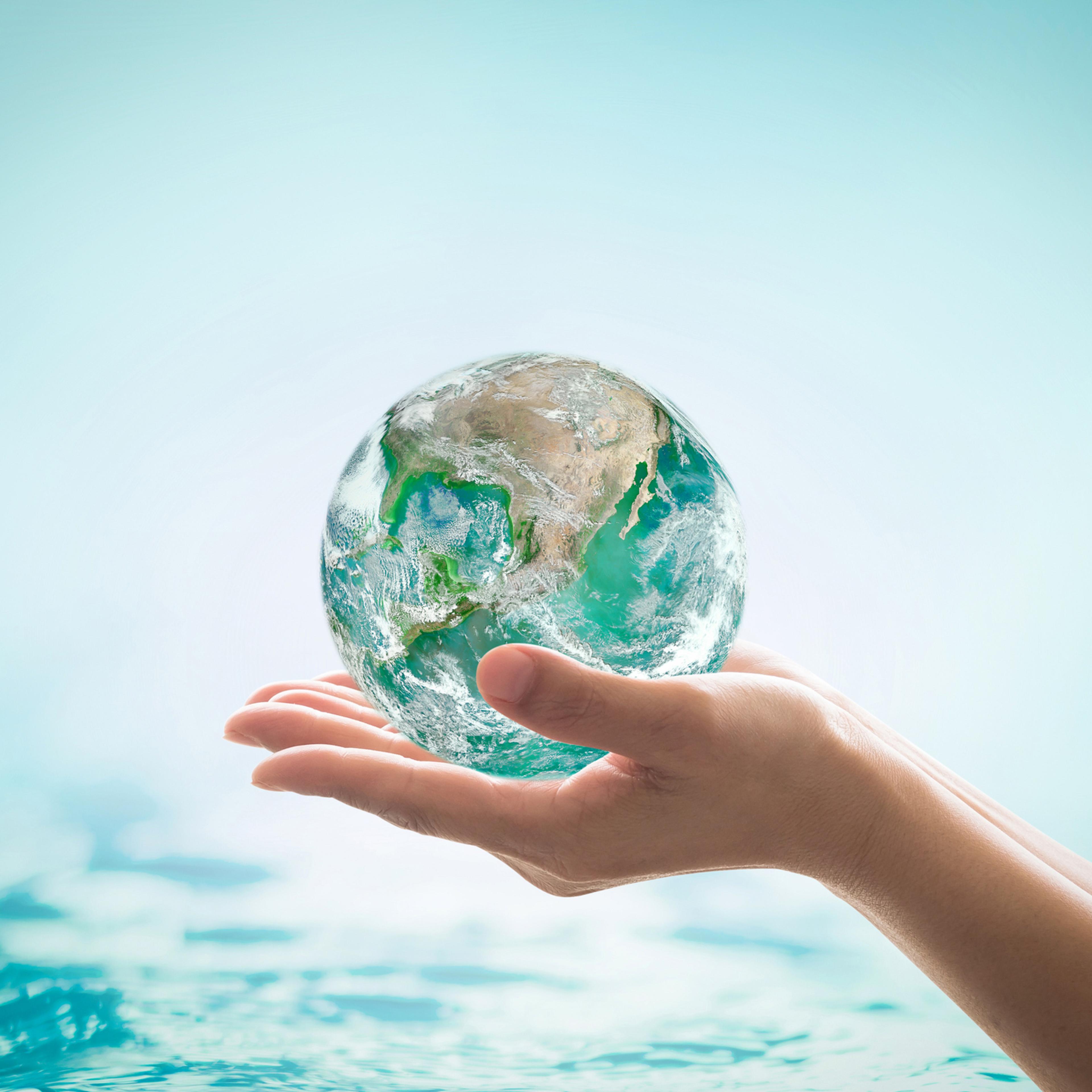 World ocean day, saving water campaign, sustainable ecological ecosystems concept with green earth on woman's hands on blue sea background : Element of this image furnished by NASA