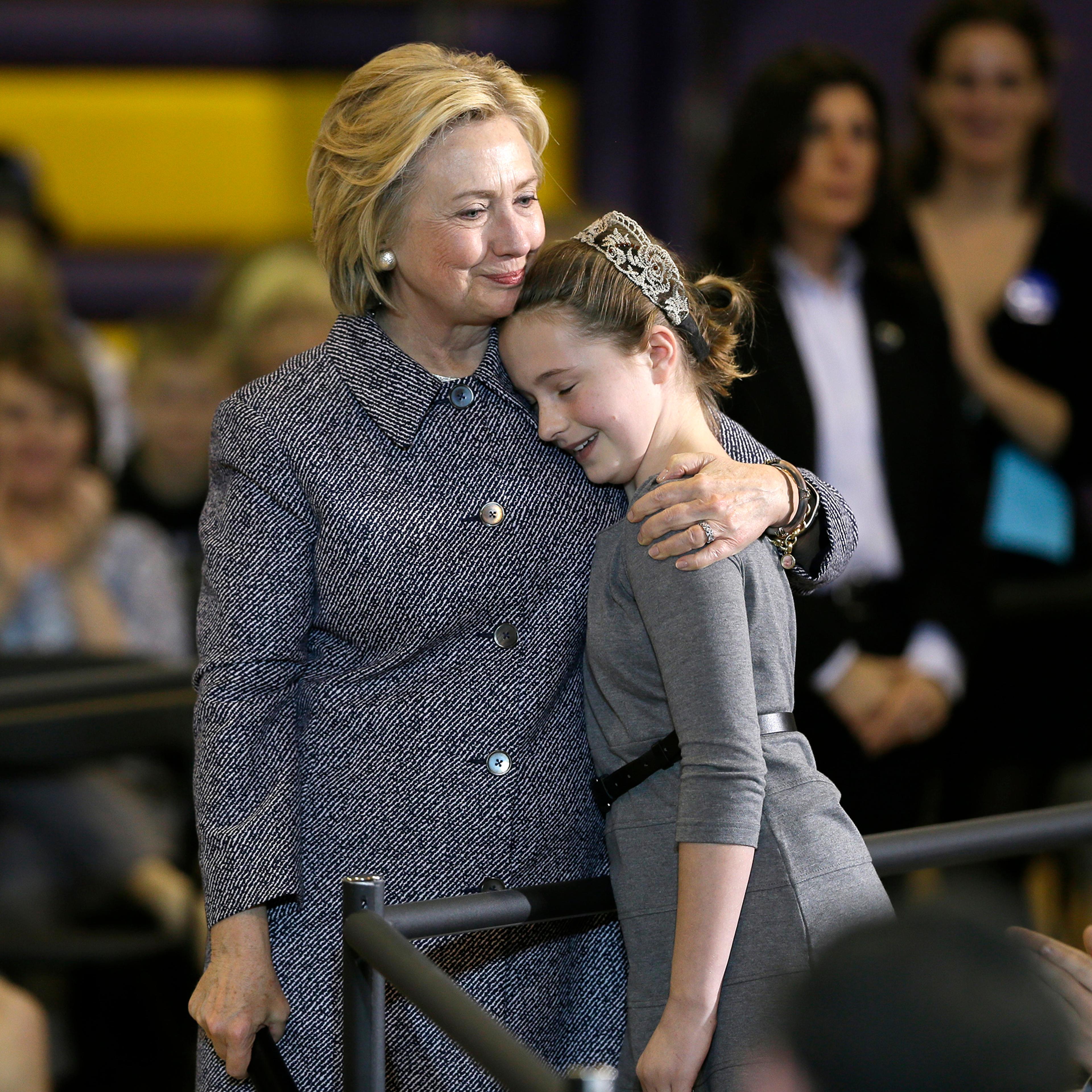 Hillary Clinton gets a hug from fifth-grader Hannah Tandy during a town hall meeting at Keota High School, on Dec. 22, 2015, in Keota, Iowa.