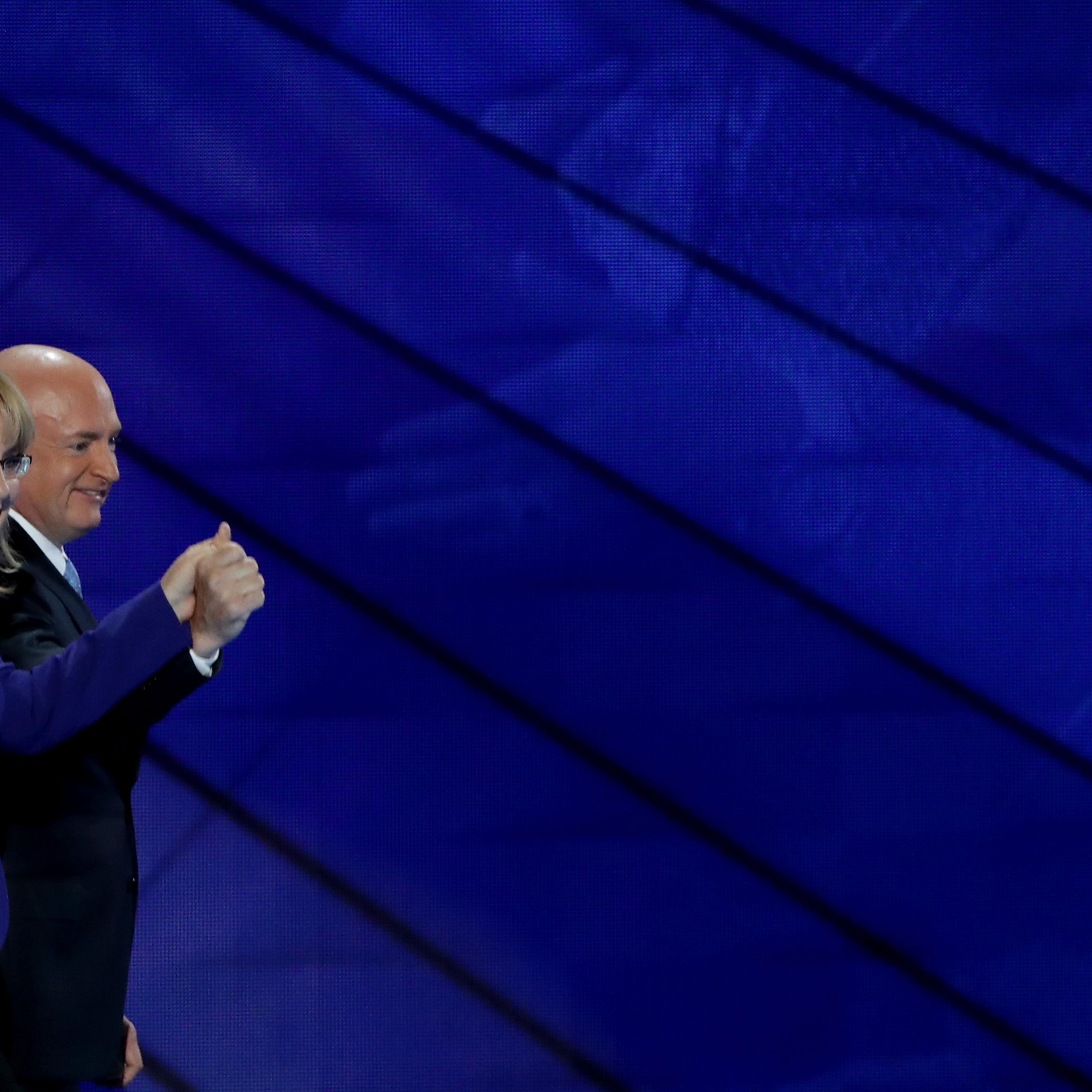Former Congresswoman Gabby Giffords and her husband, retired NASA Astronaut and Navy Captain Mark Kelly, hold hands as they walk off stage on the third day of the Democratic National Convention, July 27, 2016 in Philadelphia.