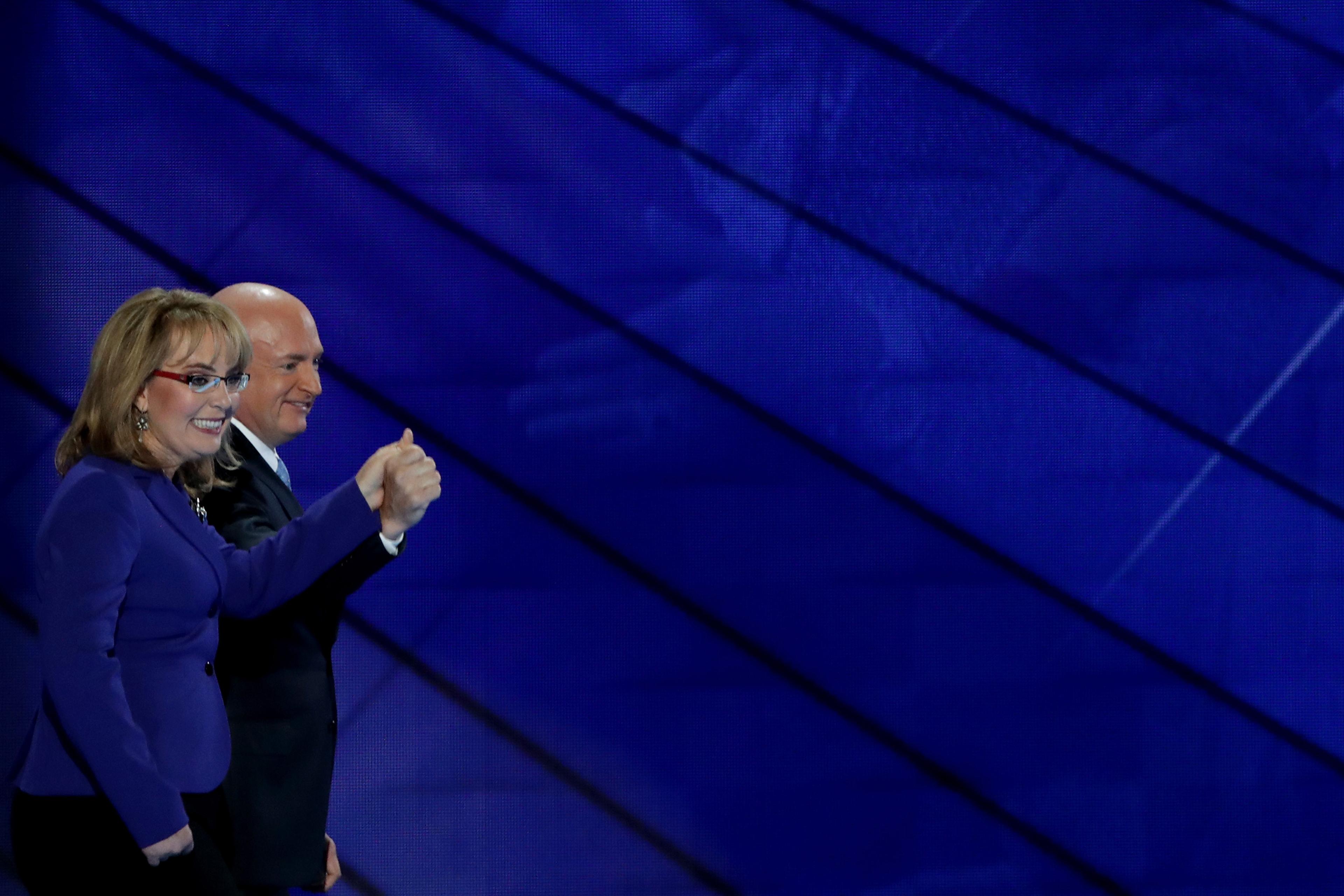 Former Congresswoman Gabby Giffords and her husband, retired NASA Astronaut and Navy Captain Mark Kelly, hold hands as they walk off stage on the third day of the Democratic National Convention, July 27, 2016 in Philadelphia.
