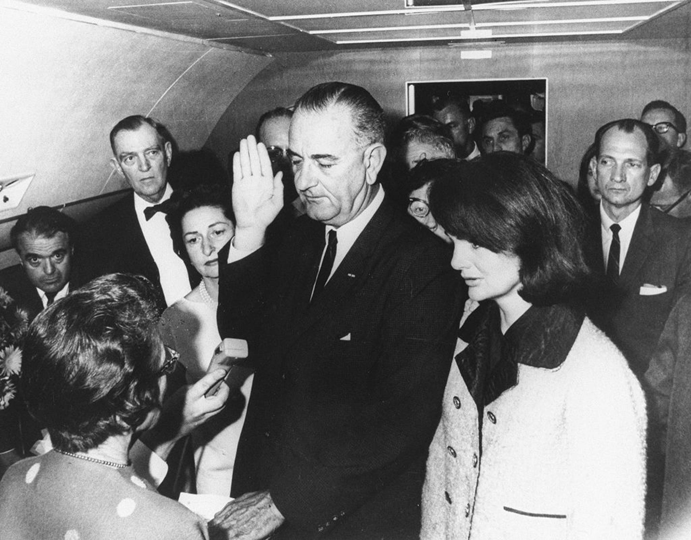 Lyndon B. Johnson is sworn in as President by federal Judge Sarah T. Hughes on Air Force One on Nov. 22, 1963, in Dallas, following the assassination of President John F. Kennedy. He's flanked by Jacqueline Kennedy (right) and wife Lady Bird Johnson (left). 
