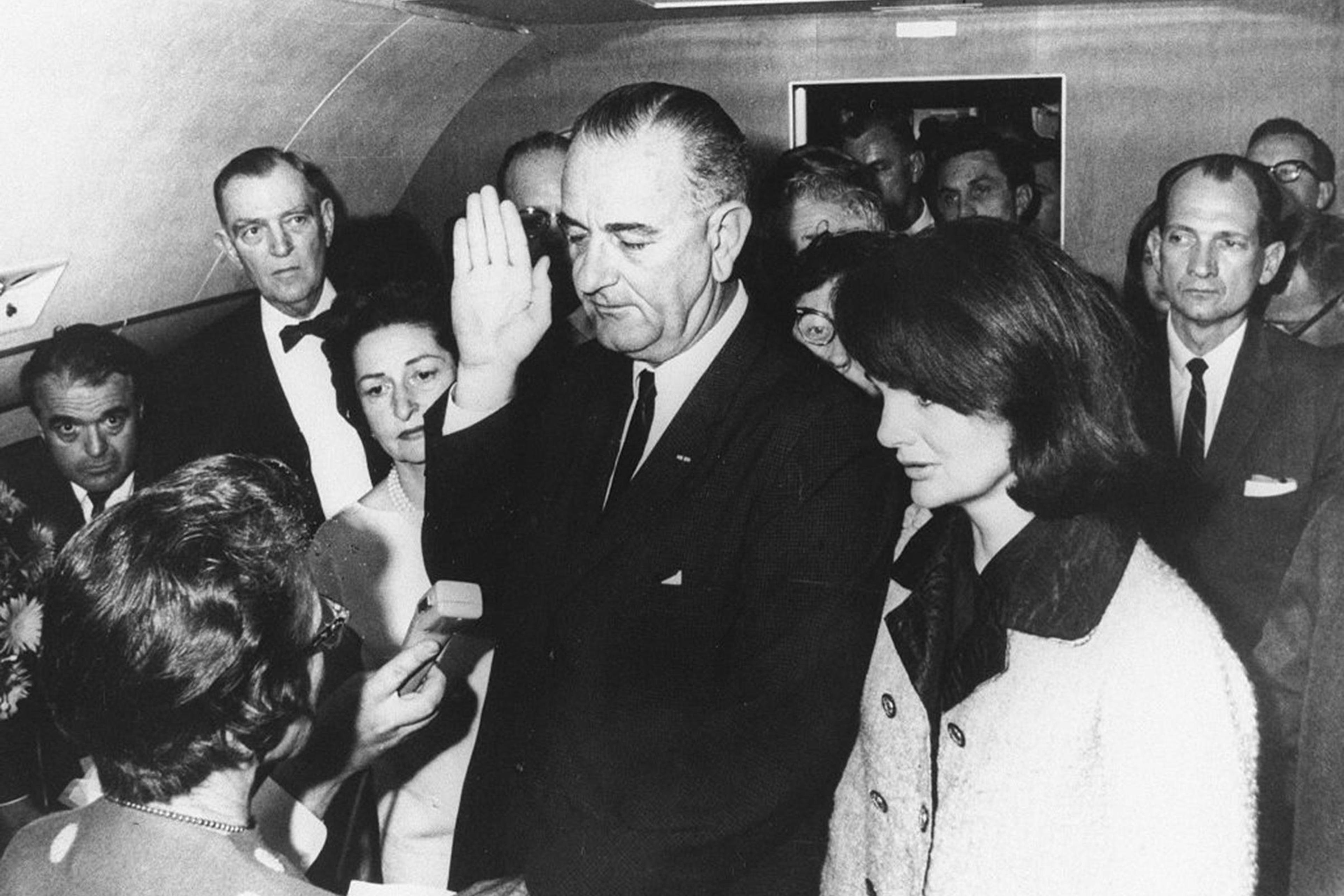 Lyndon B. Johnson is sworn in as President by federal Judge Sarah T. Hughes on Air Force One on Nov. 22, 1963, in Dallas, following the assassination of President John F. Kennedy. He's flanked by Jacqueline Kennedy (right) and wife Lady Bird Johnson (left).
