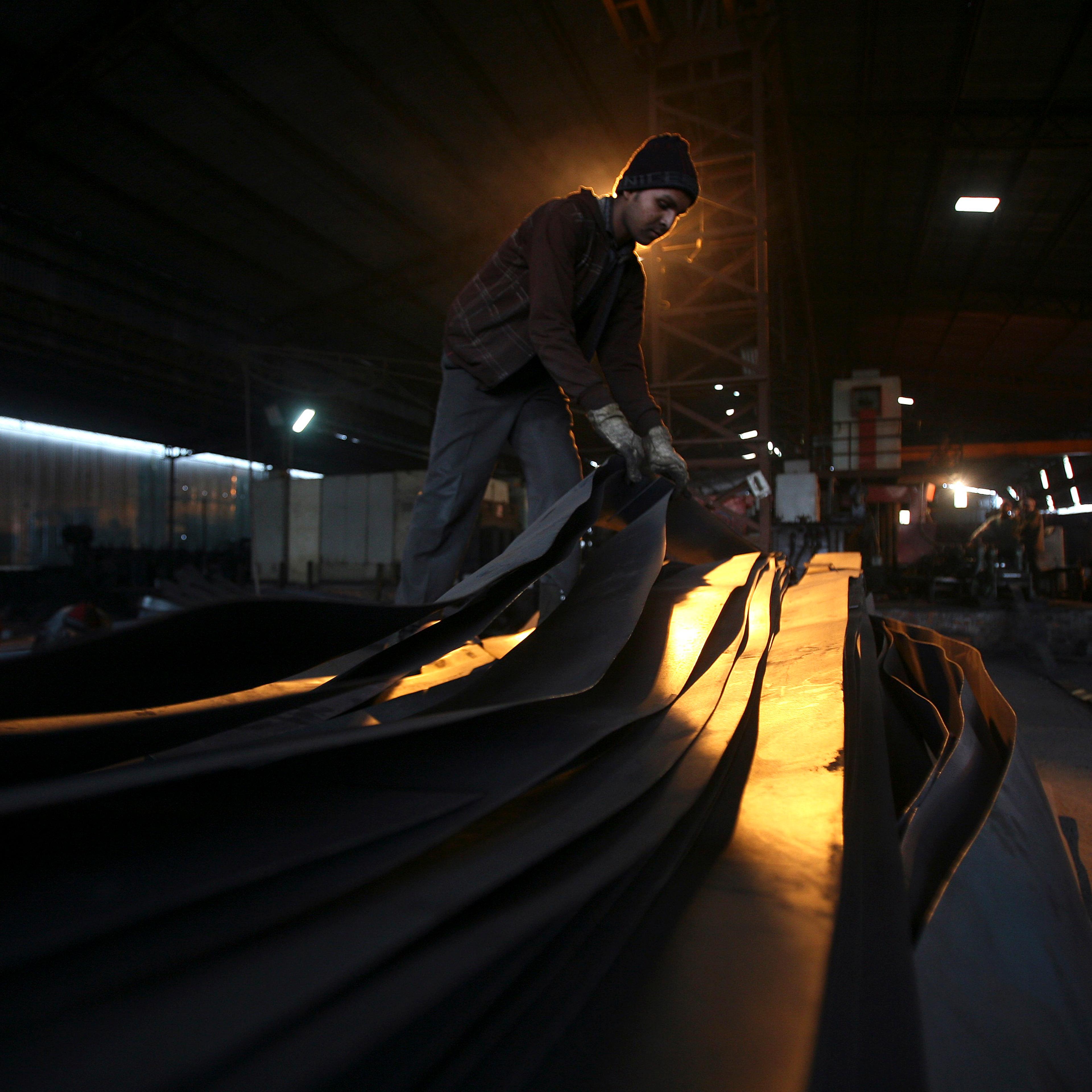 An employee works inside an iron factory on the outskirts of Jammu