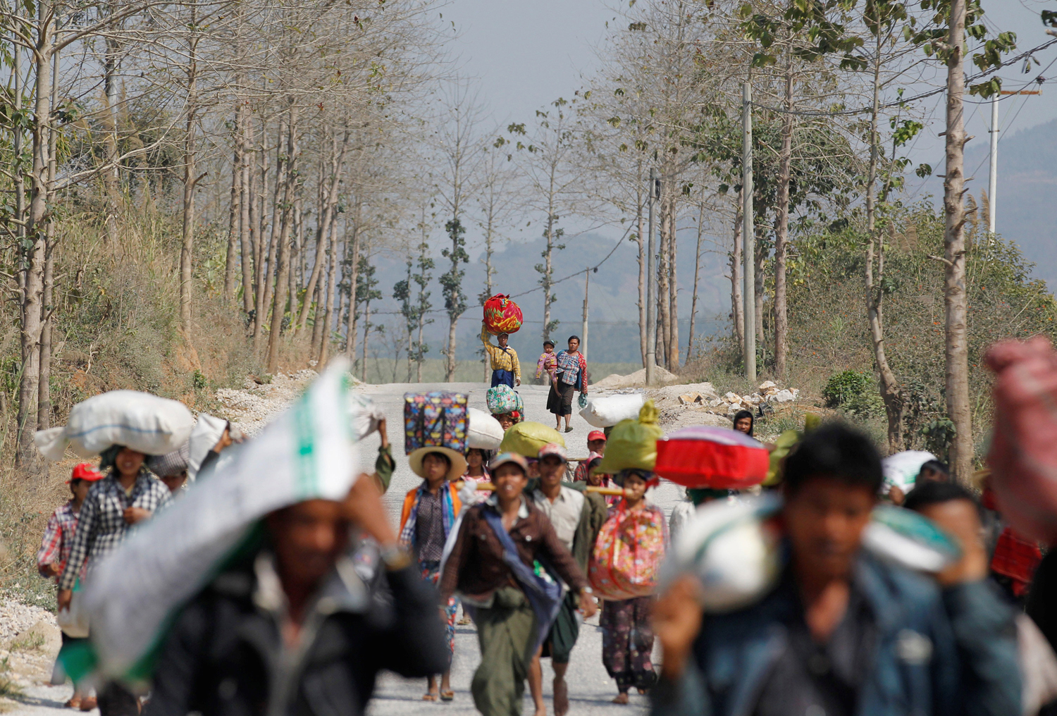People who are displaced by the fighting in Laukkai move towards a rescue convoy