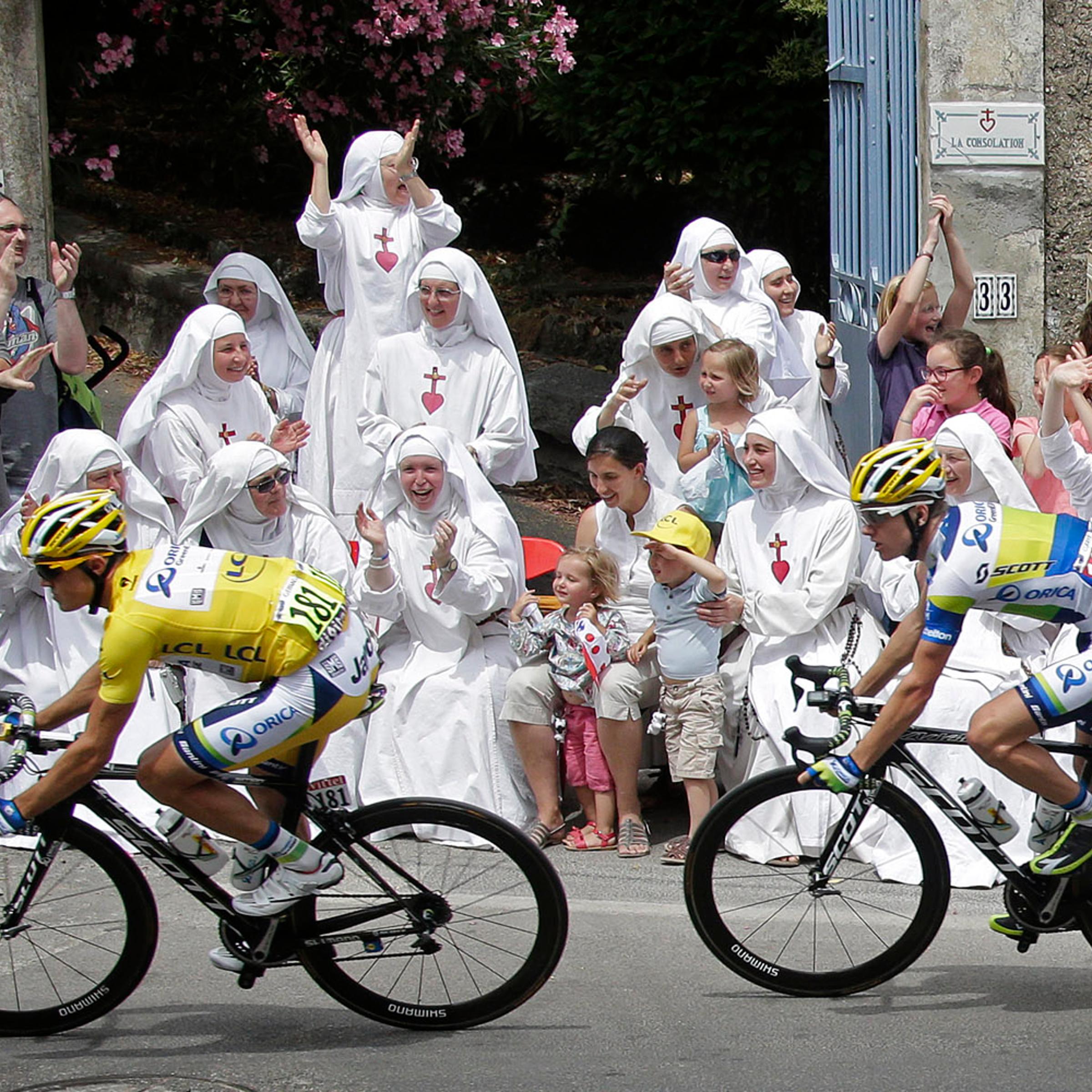 Race leader yellow jersey holder Orica Greenedge team rider Simon Gerrans of Australia cycles past Sisters of the Consolation congregation during the 228.5 km fifth stage of the centenary Tour de France cycling race from Cagnes-Sur-Mer to Marseille