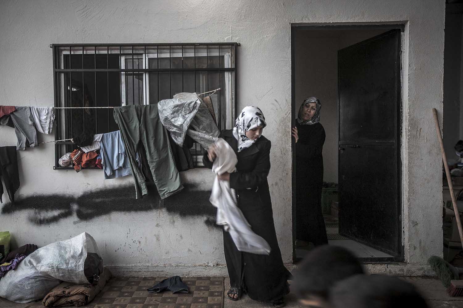 Aug. 31, 2012. Syrian refugee women take temporary shelter in a covered parking area at the Azaz border check point, established by the FSA for those fleeing army shelling in the northern villages of Aleppo province. Due to thousands of Syrian refugees crossing into Turkey since the start of the conflict, the Turkish government has closed the border, leaving hundreds of families—predominantly women and children—stuck along the border areas.