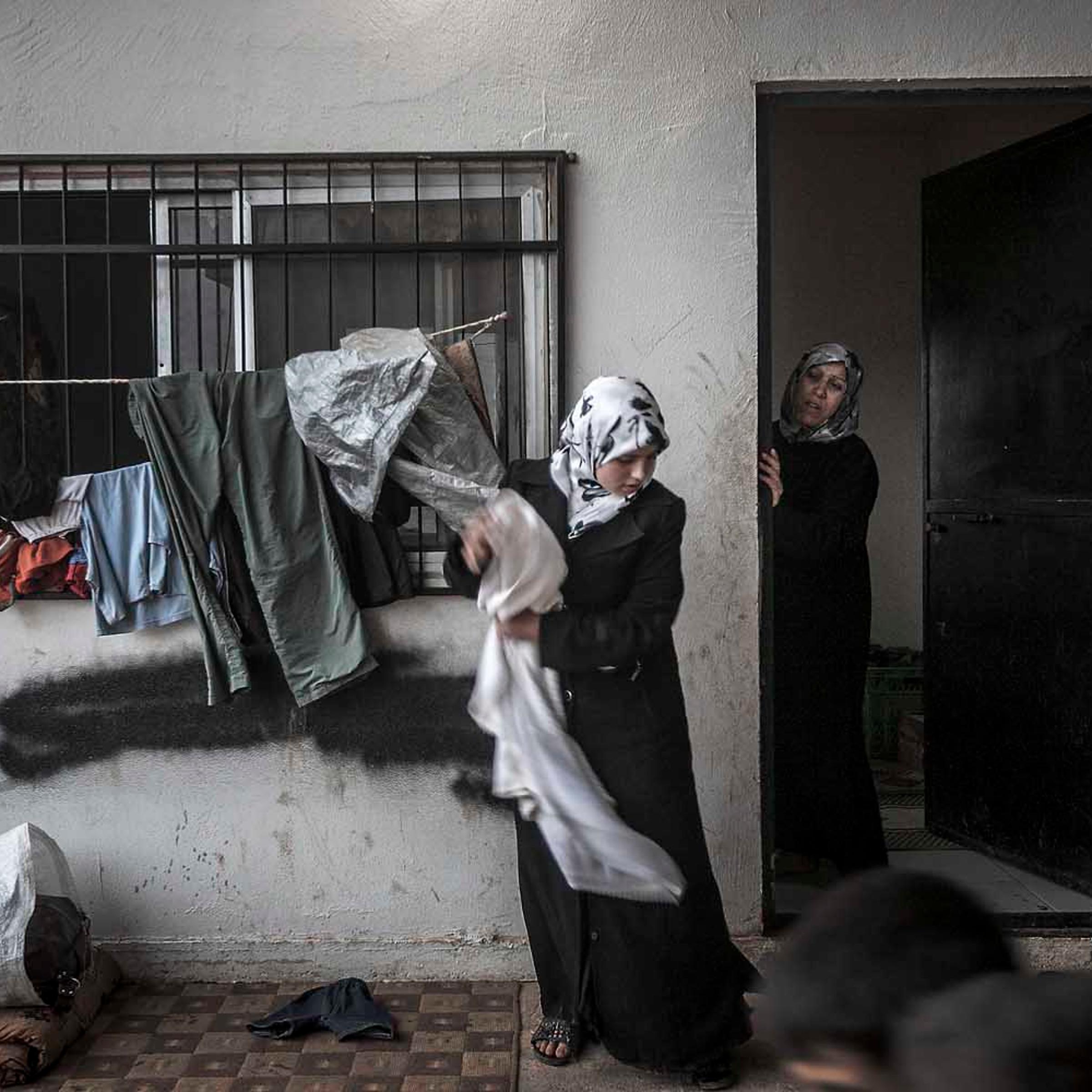Aug. 31, 2012. Syrian refugee women take temporary shelter in a covered parking area at the Azaz border check point, established by the FSA for those fleeing army shelling in the northern villages of Aleppo province. Due to thousands of Syrian refugees crossing into Turkey since the start of the conflict, the Turkish government has closed the border, leaving hundreds of families—predominantly women and children—stuck along the border areas.