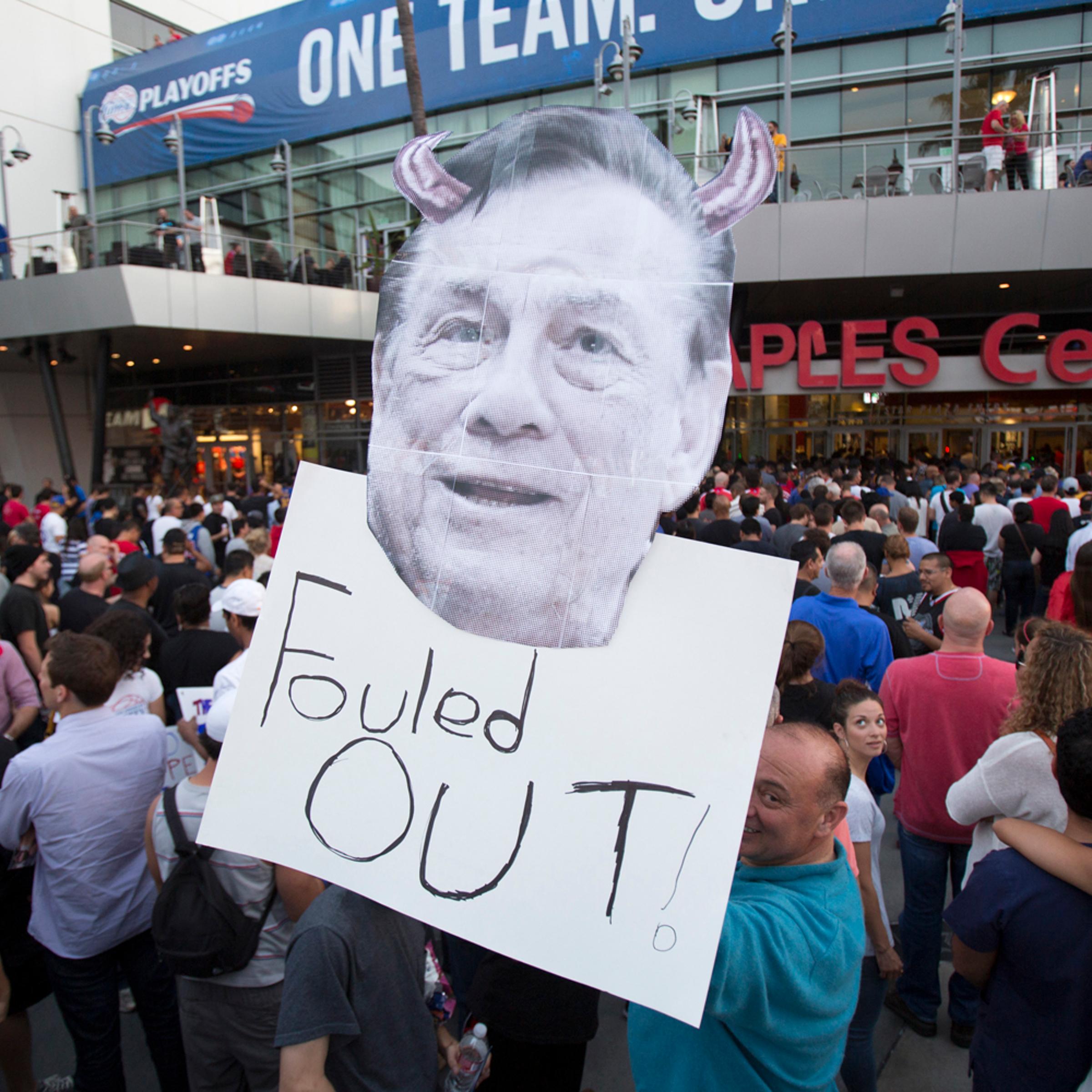 A supporter holds a photo cutout of Los Angeles Clippers owner Donald Sterling while standing in line for the NBA Playoff game 5 between Golden State Warriors and Los Angeles Clippers at Staples Center in Los Angeles