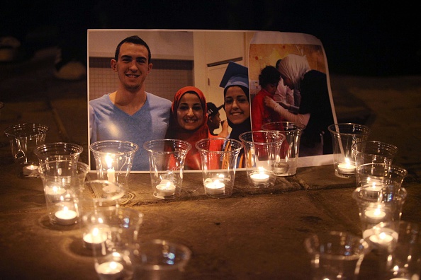 Candles are seen as a group of demonstrators gather in front of American Embassy in Amman to protest against the Chapel Hill shooting, in Amman, Jordan on Feb. 16, 2015.