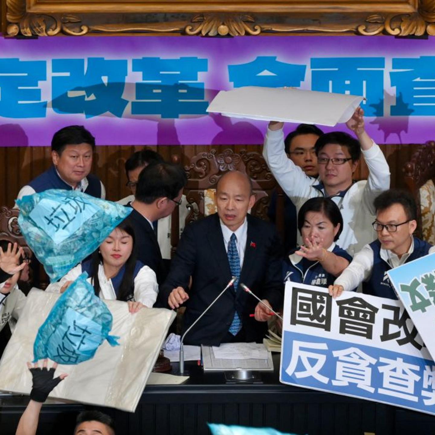 Lawmakers from main opposition Kuomintang (KMT) stop garbage bags thrown by ruling Democratic Progressive Party (DPP) legislators during voting for the Parliament reform bill in Taipei on May 28, 2024.