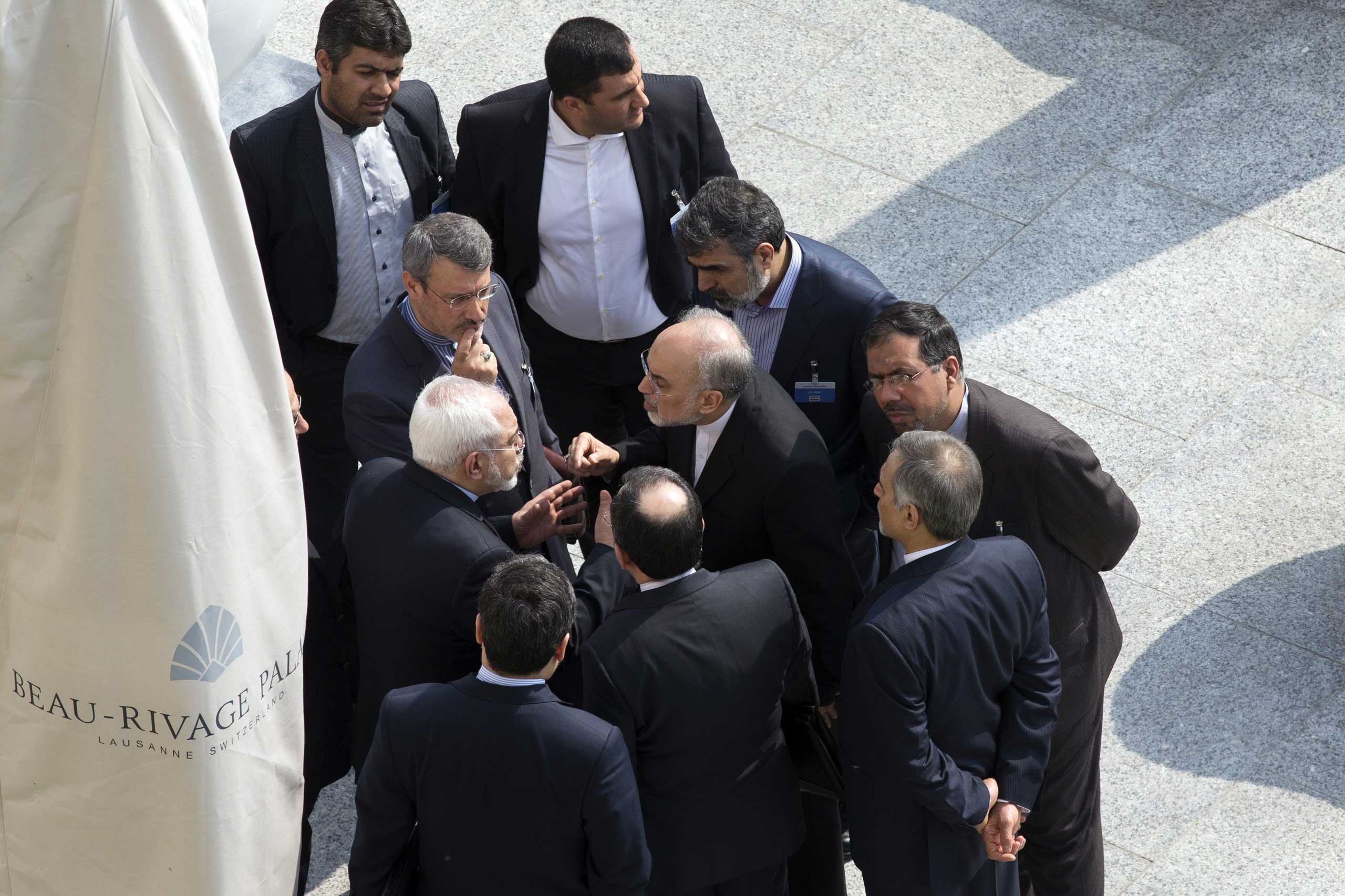 Iran's Foreign Minister Mohammad Javad Zarif, center, and head of the Atomic Energy Organization of Iran Ali Akbar Salehi, center right, talk outside with aides after a morning negotiation session with U.S. Secretary of State John Kerry over Iran's nucle
