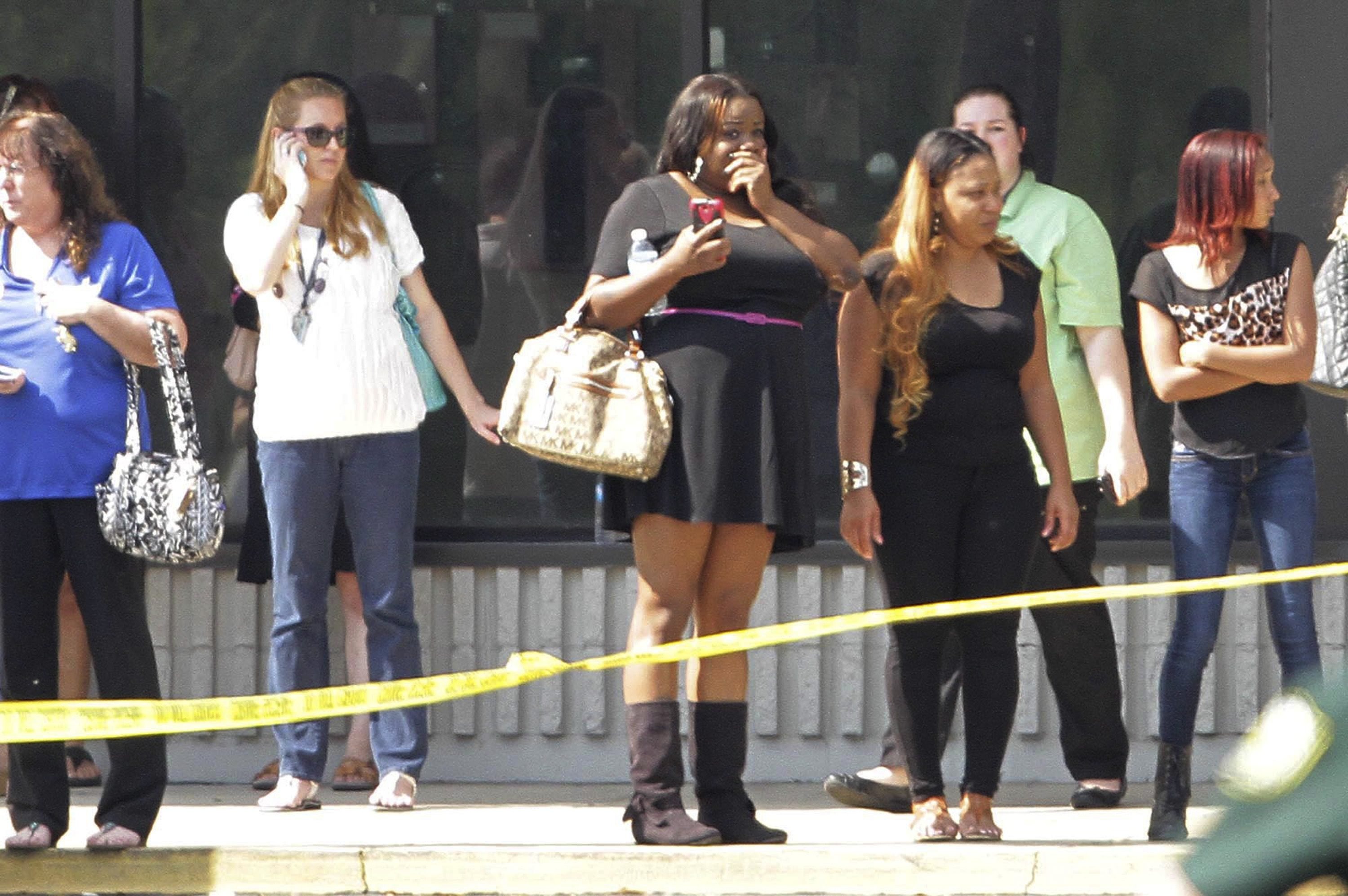 Parents and onlookers stand behind police tape after a vehicle crashed into a child care center in Winter Park