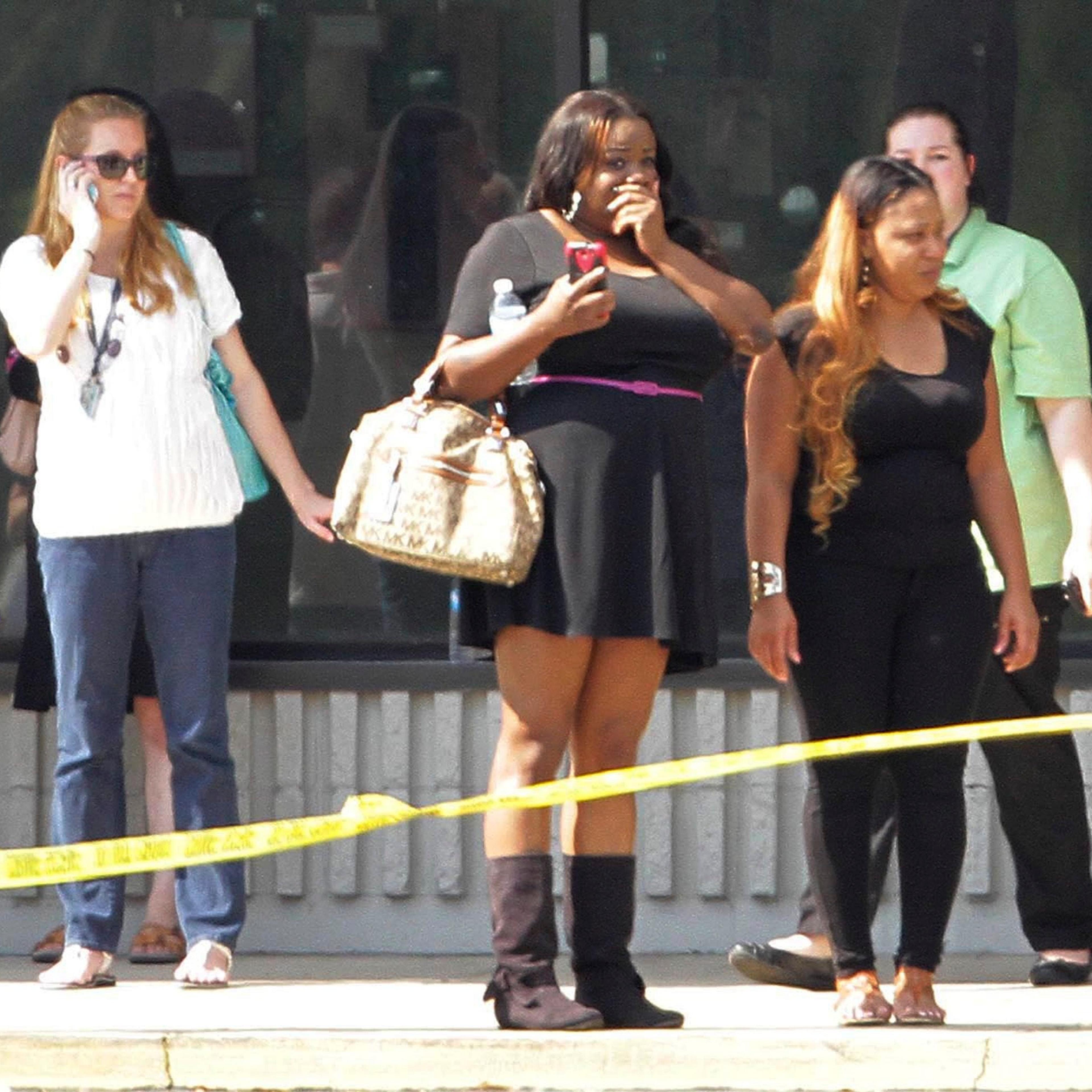 Parents and onlookers stand behind police tape after a vehicle crashed into a child care center in Winter Park