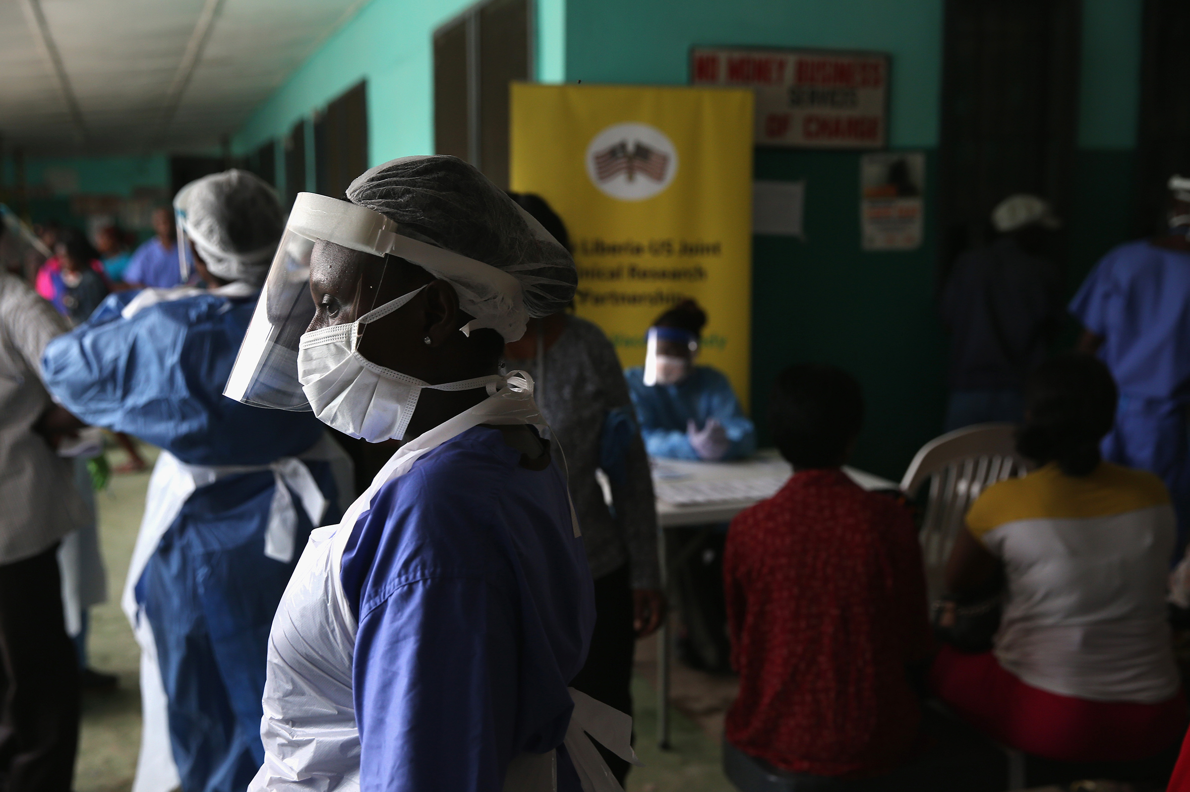 Health workers in protective clothing await patients in the outpatient lounge of Redemption Hospital, formerly an Ebola holding center, on Feb. 2, 2015 in Monrovia, Liberia.