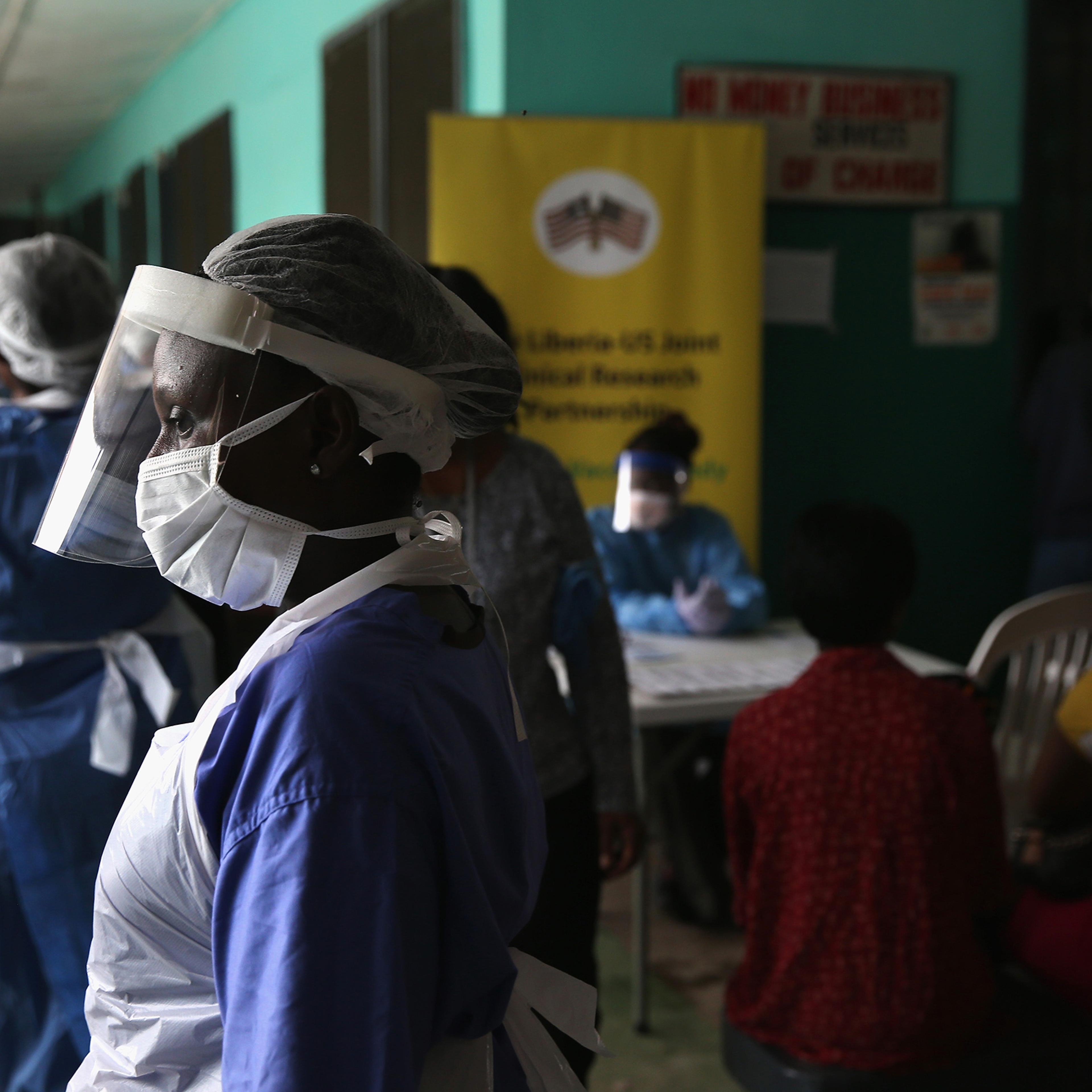 Health workers in protective clothing await patients in the outpatient lounge of Redemption Hospital, formerly an Ebola holding center, on Feb. 2, 2015 in Monrovia, Liberia.