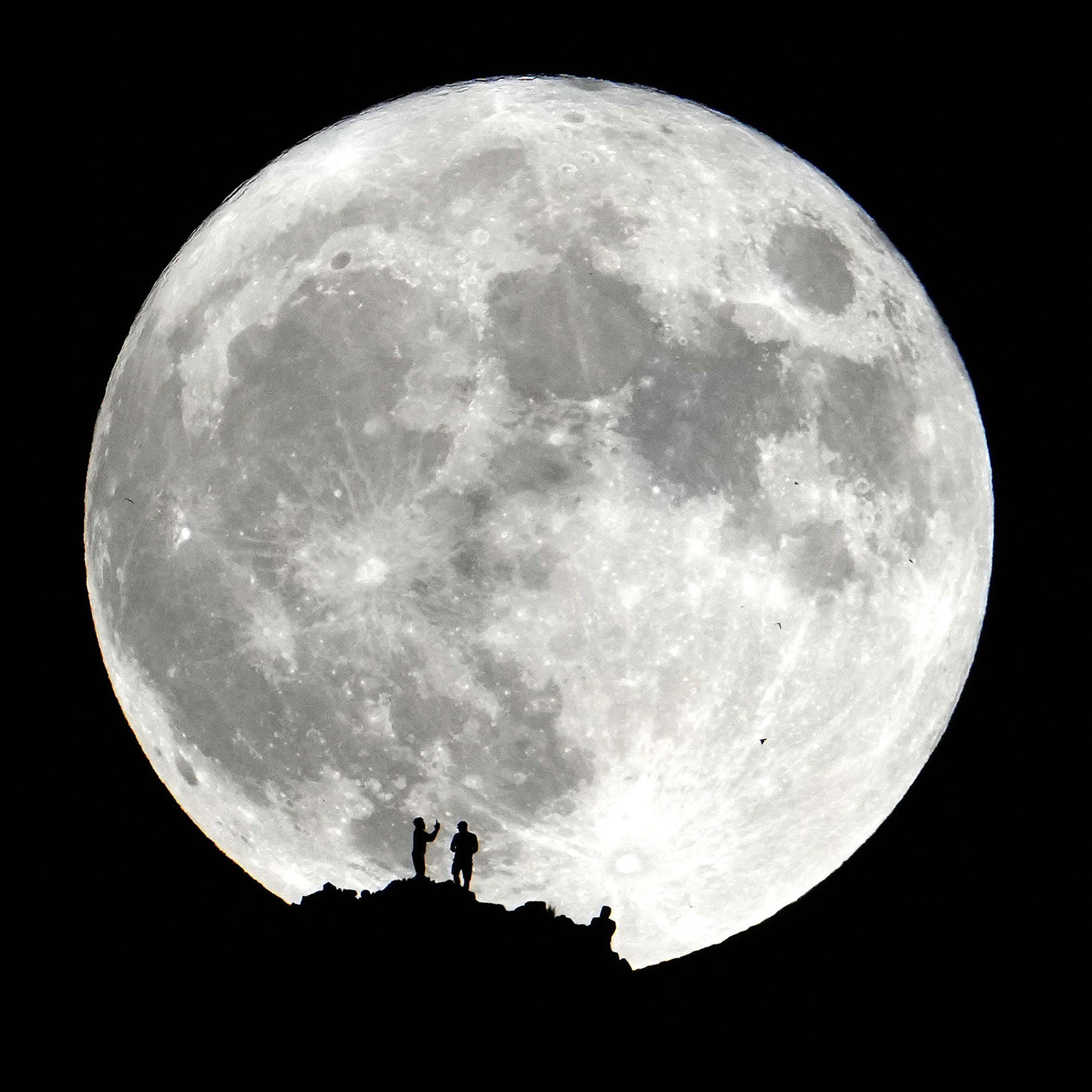 Hikers watch the Super Blue Moon from the summit of Piestewa Peak in Phoenix on Aug. 30, 2023.