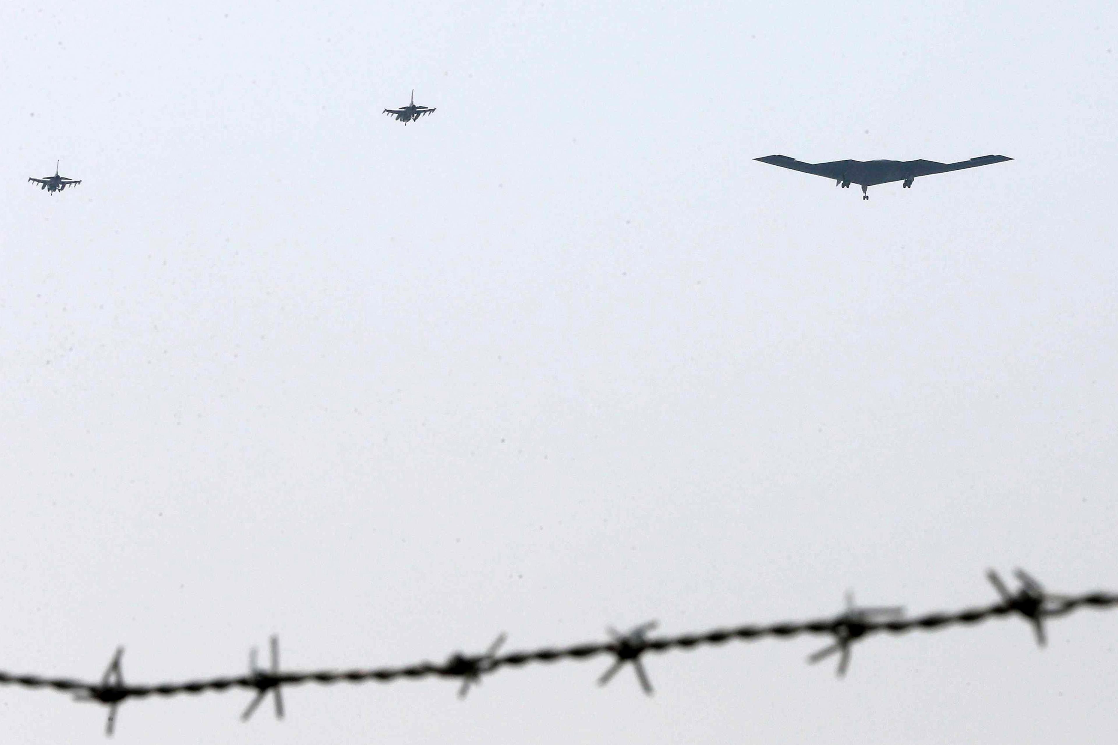 The United States air force's B-2 stealth bomber, center, flies over near the Osan U.S. Air Base in Pyeongtaek, south of Seoul, South Korea, Thursday, March 28, 2013. A day after shutting down a key military hotline, Pyongyang instead used indirect commu